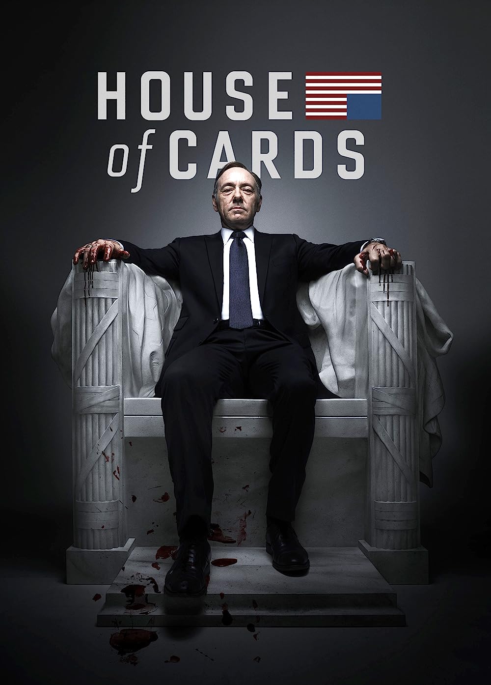 Portada de la serie "House of Cards" un ejemplo de inteligencia artificial en netflix. En esta imagen aparece un hombre sentado sobre una especie de trono de marmol y el nombre de la serie por encima de su cabeza con la bandera de EEUU en el lateral superior derecho. El fondo de la imagen es gris con un foco de luz blanco en el centro. El señor lleva puesto un traje negro con una camisa blanca y una corbata en un gris muy oscuro